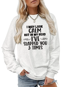 Detail of the white oversized sweatshirt featuring humorous black quote text and soft fabric