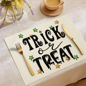 Detailaufnahme von Leinentischset mit Trick or Treat Schriftzug und bunten Sternen