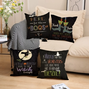 Set of 4 Halloween linen pillow covers with festive prints on a cozy home sofa