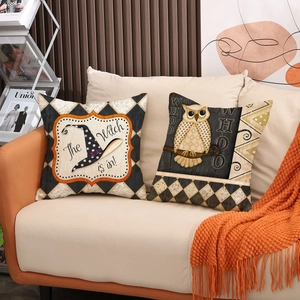 Set of two Halloween witch hat and owl print throw pillow covers on a cozy sofa