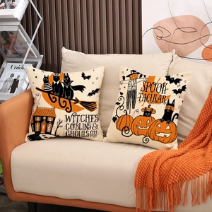 Set of two Halloween pumpkin and black cat throw pillow covers on a cozy sofa