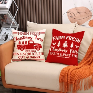 Christmas farmhouse linen pillow covers with red truck and farm fresh tree print on a sofa