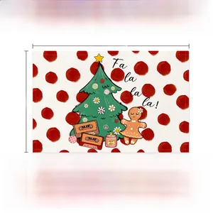 Détail d'un set de table de Noël en lin avec motif pain d'épice et pois rouges
