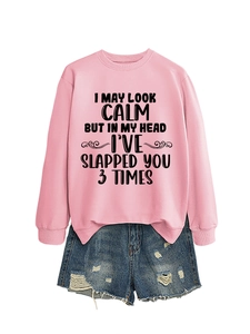 Detail of pink crewneck sweatshirt with black English slogan paired with ripped denim shorts