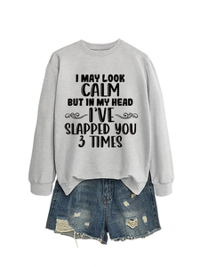 Flat lay of gray sweatshirt with sarcastic slogan and ripped denim shorts in casual style