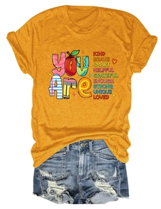 Flat lay of mustard yellow t-shirt with inspirational text and distressed denim shorts