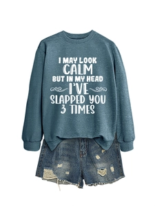 Detail of blue crewneck sweatshirt with slogan print and distressed denim shorts
