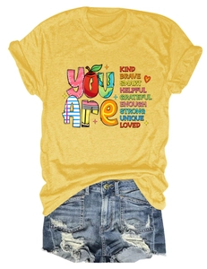 Flat lay of a yellow graphic T-shirt with motivational text paired with denim shorts