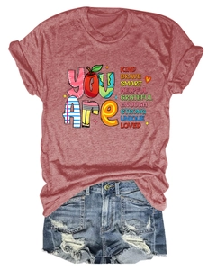 Flat lay of a red cotton T-shirt with inspirational text paired with denim shorts