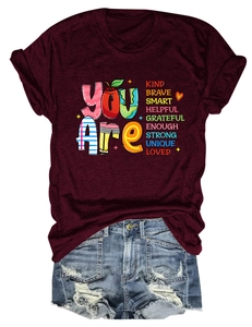 Flat lay of wine red crew neck T-shirt with inspirational text and denim shorts