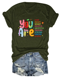 Flat lay of olive green crew neck T-shirt with inspirational text and denim shorts