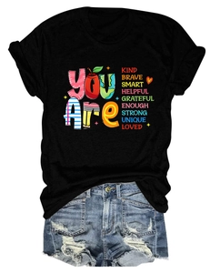 Close-up of You Are Kind Brave printed text on black cotton short sleeve t-shirt