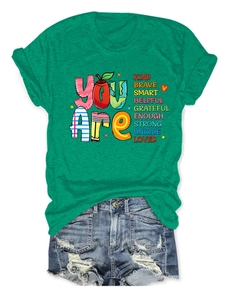 Detail of green T-shirt with positive quote print and distressed denim shorts