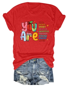 Detail of red T-shirt with 'You Are Kind Brave' colorful print and denim shorts