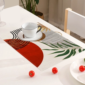 Detailansicht eines Platzsets aus Leinen mit roten Motiven und Blättern auf dem Tisch