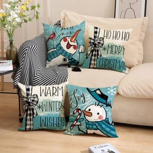 Set of four Christmas linen pillow covers featuring snowmen and winter themes on a sofa