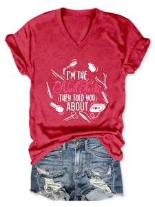 Detail of red V-neck T-shirt with I'M THE Nail Tech graphic and manicure tool icons