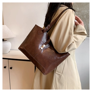 Détail du sac fourre-tout vintage marron avec fermoir tournant doré et double bandoulière