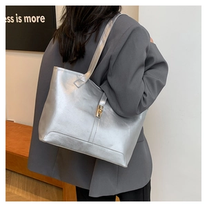 Détail du sac cabas argenté avec fermoir rotatif doré et bandoulière fixe de mode