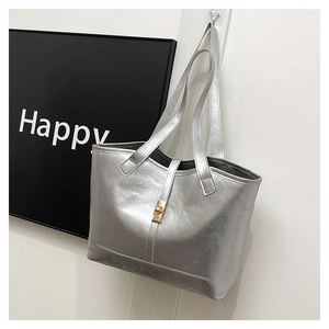 Détail du sac cabas argenté métallisé avec boucle dorée et texture cuir raffinée