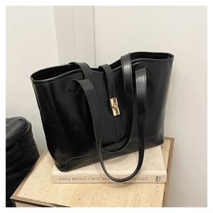 Détail du sac cabas noir avec fermoir tournant doré et texture mate délicate