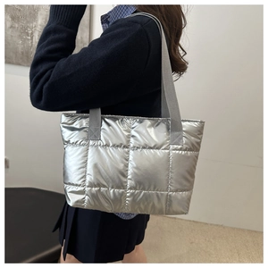 Detail shot of silver quilted puffer tote bag with metallic finish and grey straps