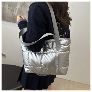 Detail of silver quilted tote bag with metallic finish and padded puffy square texture