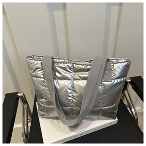 Detail of silver metallic quilted tote bag with wide grey woven shoulder strap