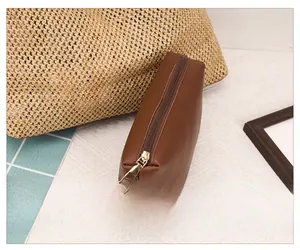 Detail shot of brown leather tote bag with gold metal zipper and sleek finish