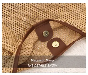 Close-up of the light gold magnetic buckle on a woven straw bag with brown leather trim
