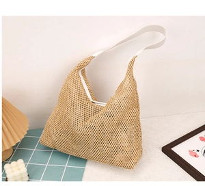 Close-up of the woven straw texture and white leather strap of this hobo tote bag