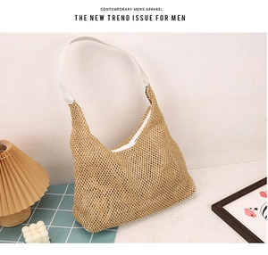 Detail of woven straw tote bag with contrasting white leather shoulder strap and texture