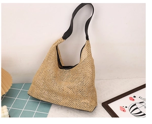 Detail of the woven texture and black leather strap on a large tote shoulder bag