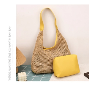 Detail shot of straw woven shoulder bag with bright yellow inner pouch on a cozy desk