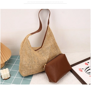 Detail of woven straw tote bag with brown PU zip pouch and shoulder strap on table