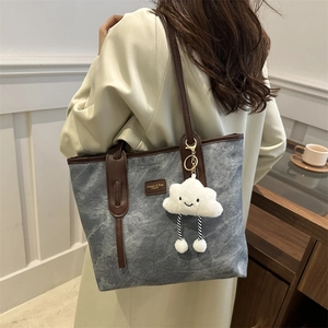Retro grey canvas tote bag with brown leather straps and plush cloud charm for daily commute