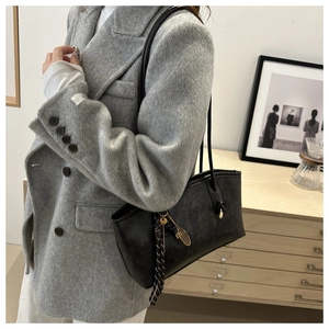 Close-up of black tote bag with tennis racket charm and Fashion & Bags embossing