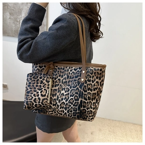 Detail of leopard print tote bag with a matching small pouch and dark brown leather straps