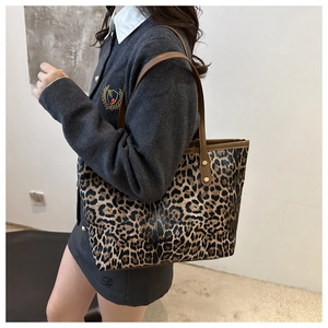 Chic leopard print tote bag with brown leather straps worn by model for daily commute style