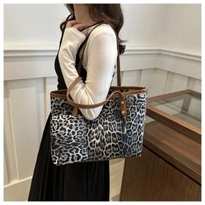 Leopard print tote bag detail showing large capacity and matching small pouch hanging on strap