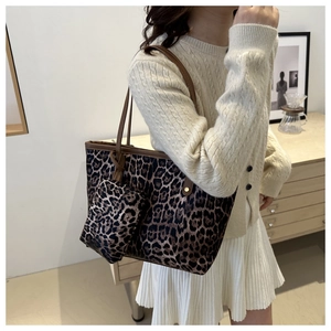 Detail of leopard print tote bag with brown leather straps and matching mini pouch bag