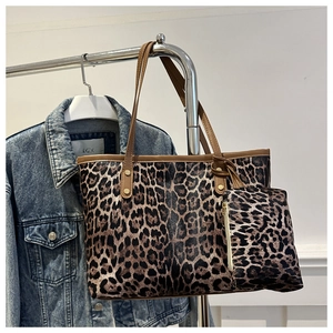 Detail of leopard print tote bag with brown handles and matching small pouch