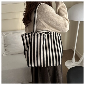 Détail du sac cabas en toile à rayures noires et blanches dans un décor intérieur