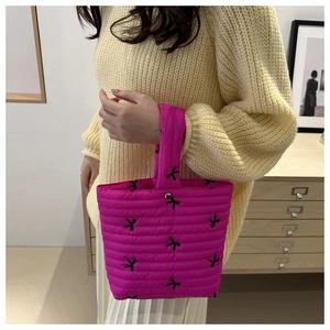 Borsa a secchiello trapuntata magenta con ricamo fiocco nero e chiusura a scatto