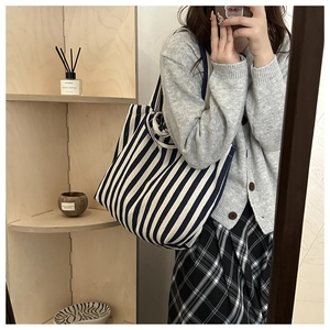 Détail de la texture d'un sac cabas en toile à rayures bleues et blanches style décontracté