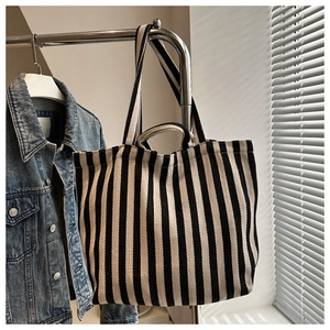 Gros plan d'un sac cabas en toile à rayures noires et blanches avec doubles bandoulières