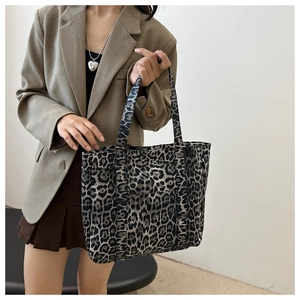 Close-up of leopard print canvas tote bag with functional front pocket in lifestyle scene