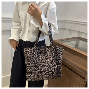 Detail view of large leopard print canvas tote bag styled with a minimalist outfit