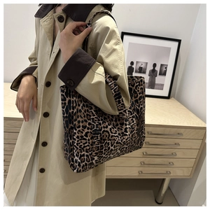 Close-up of leopard print tote bag with shoulder strap paired with autumn trench coat