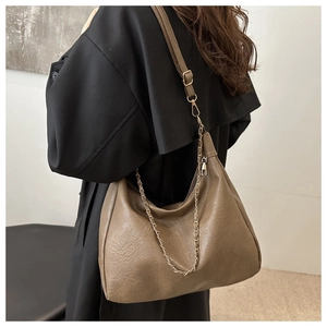 Détail du sac hobo marron rétro avec texture cuir naturel et bandoulière chaîne dorée